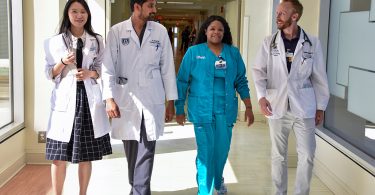 Four medical employees walking in hallway