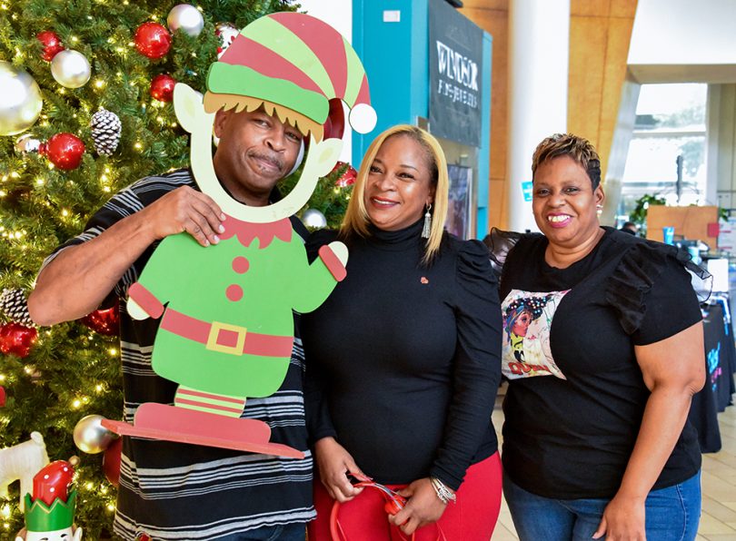 Man with elf cutout and two women