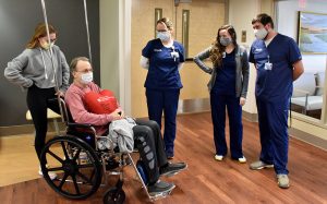 Man in wheelchair talking to four nurses