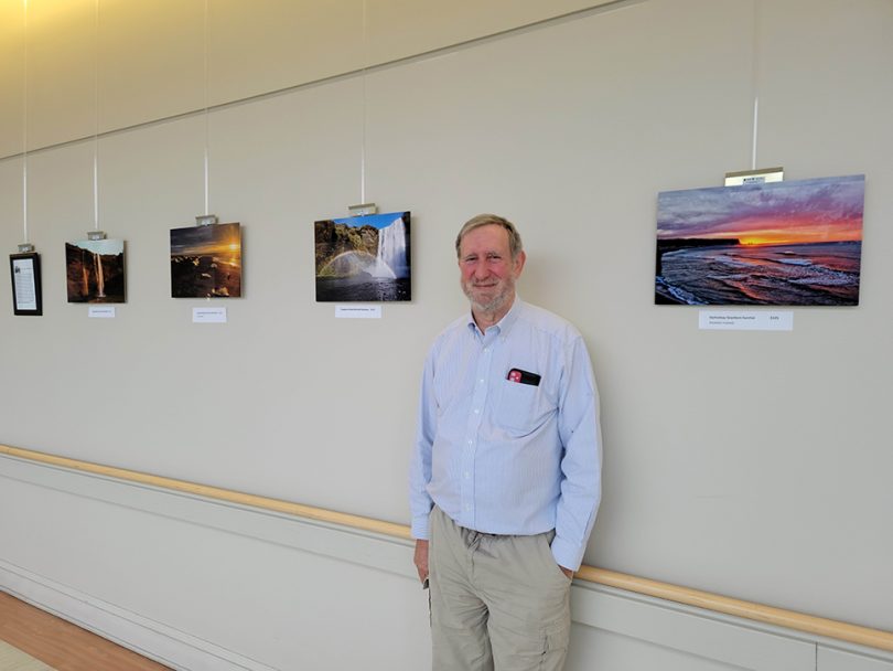 Man standing with photos on wall